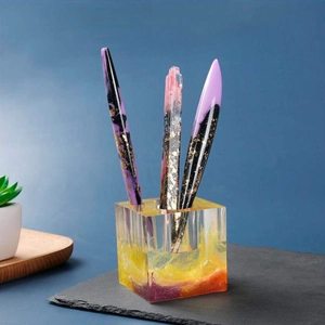 Detalle de set de papelería en resina con arena dorada púrpura y portaplumas de arte