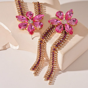 Close-up of elegant flower earrings with pink rhinestones and long purple crystal tassels
