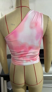Close-up of pink and white tie-dye one-shoulder crop top with side ruched details