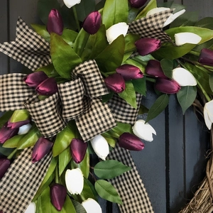 Macro detail of silk tulips with a plaid ribbon bow on a natural rattan spring wreath