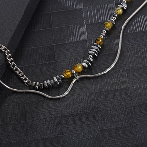 Macro shot of double-layered silver chain necklace with brown and metallic grey beads