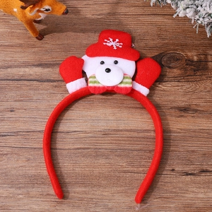 Macro detail of plush Christmas headband with red gloves and cute bear on wood surface
