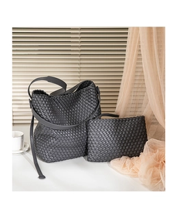 Detailed view of dark grey hand-woven PU bucket bag and matching inner pouch set