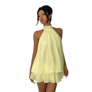 Detail of light yellow halter chiffon dress featuring flowing layered ruffle hemline