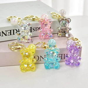 Set of six colorful acrylic bear keychains in candy colors displayed on vintage books