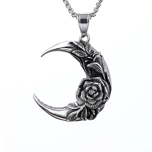 Macro shot of silver crescent moon pendant with rose relief and vintage steel texture