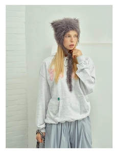 Detail of plush grey cat ear beanie with long straps worn with a casual grey hoodie