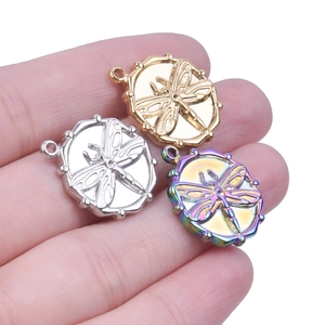 Macro view of stainless steel dragonfly pendants in gold, silver, and rainbow colors
