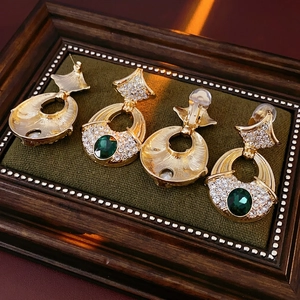 Vintage gold ginkgo leaf earrings with emerald green stones and diamond accents