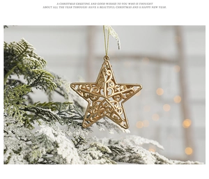 Close-up of golden hollow star ornament on a snowy Christmas tree branch with bokeh lights