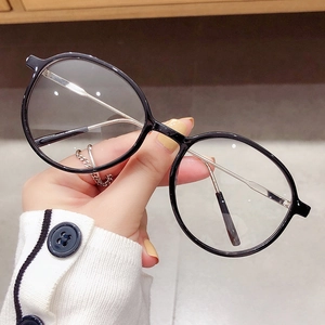 Klassische runde schwarze Brille mit silbernen Metallbügeln in der Hand gehalten
