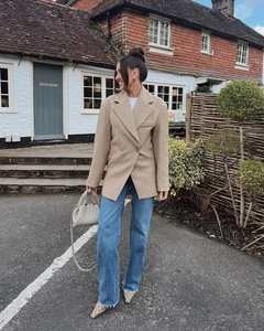 Chic khaki double-breasted blazer for women paired with blue jeans in an urban street setting