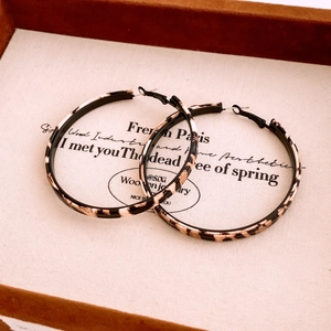 Detail of round leopard print earrings with vintage tortoiseshell texture on display