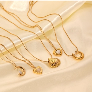 Detailed collection of gold necklaces with cat eye stone and shell pendants on silk