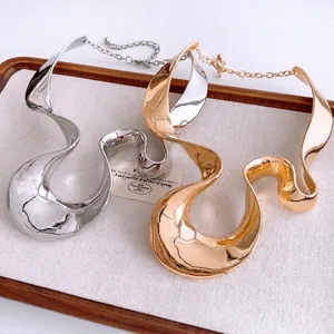 Statement necklaces with twisted metallic folds in polished gold and silver finishes