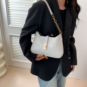 Elegant white shoulder bag with gold chain strap and square buckle on model
