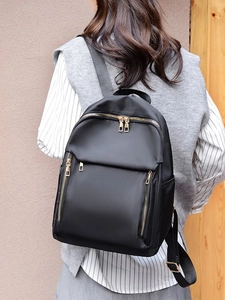 Minimalist black nylon backpack for women with gold zippers and large capacity