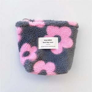 Detailed top view of grey plush pouch with pink floral pattern and zip closure