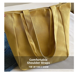 Detail of wide reinforced shoulder strap on yellow canvas tote bag for comfort