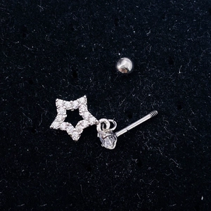 Close-up of silver star and heart cubic zirconia studs on black velvet background