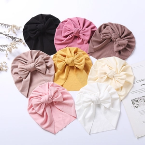 Close-up of ribbed baby turban hats with bow detail in multiple colors on clean background