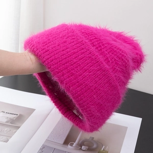 Close-up of fluffy rose pink knit beanie showing warm thick plush texture and fuzzy fibers