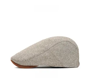 Detailed side view of British style herringbone tweed newsboy cap with brown brim