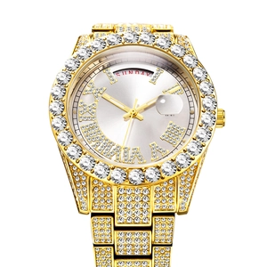 Macro shot of iced-out gold watch bezel with Roman numerals and Sunday calendar display