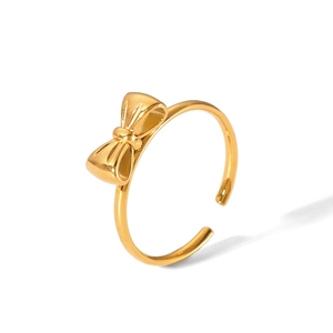 Detail view of a golden stainless steel bow ring on white background with soft shadows
