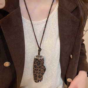 Close-up of leopard print leather pendant necklace with bronze metal snap closure detail