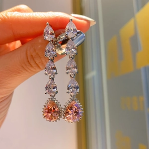 Macro shot of silver drop earrings with pink water drop gems and sparkling zircons