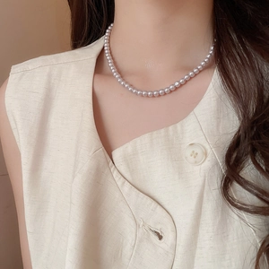 Detail of single strand lavender pearl necklace with 5-6mm beads on a model's collarbone