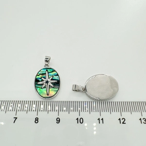 Detail showing the oval abalone shell pendant with octagonal star and smooth metal back