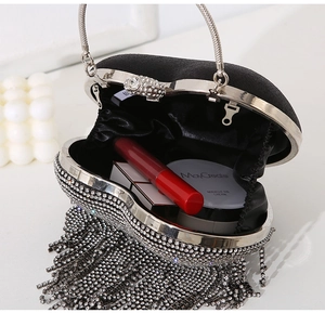Detail view of heart-shaped rhinestone evening bag showing internal capacity for cosmetics