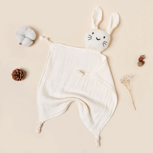 Detail of white cotton muslin baby security blanket with cute stuffed bunny head and knots