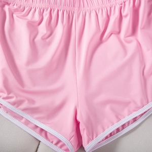 Detail of pink sports shorts with white contrast trim and precise stitching texture