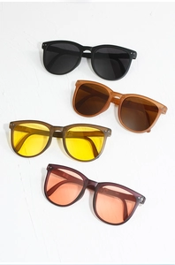 Macro shot of oval sunglasses in four colors with plastic frames and metal rivets