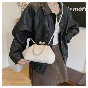 Detailed view of white faux fur handbag with elegant pearl chain and golden kiss lock