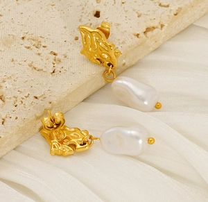 Detail view of baroque pearl drop earrings with textured gold lava metal studs