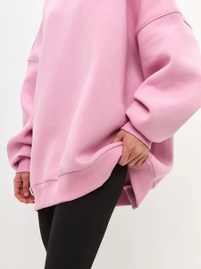 Detail shot of oversized pink hoodie featuring premium ribbed cuffs and drop shoulder seam