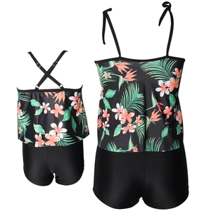 Matching two-piece floral mother and daughter swimsuits with ruffle tops and black bottoms