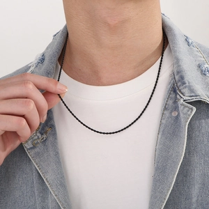 Close-up of a black twisted rope chain necklace worn by a male model for a trendy look