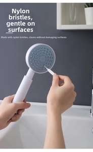 Détail d'une brosse en nylon nettoyant les buses d'une douchette pour éviter l'entartrage