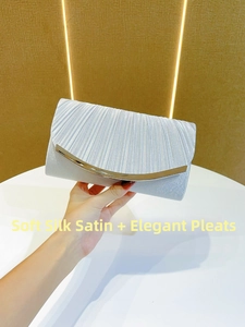 Detailed view of silver pleated silk satin clutch with gold curved metal trim