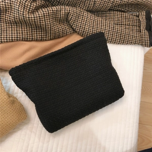Close-up of black waffle weave fabric handbag with detailed textured square pattern
