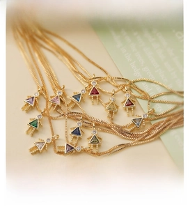 Detail of cute gold girl silhouette pendants with colorful sparkling crystals on fine chains