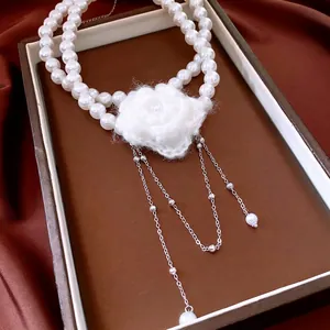 Elegant double-layered pearl necklace with white crochet flower and silver tassels
