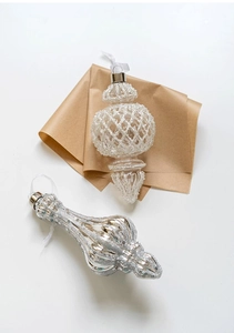 Detail of beaded lantern and silver glitter spire Christmas tree ornaments on kraft paper