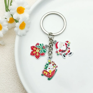 Detail showing Santa, snowman in sled, and snowflake enamel charms on a keyring
