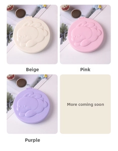 Detail of round folding mirror with cute rabbit relief in beige, pink, and purple colors